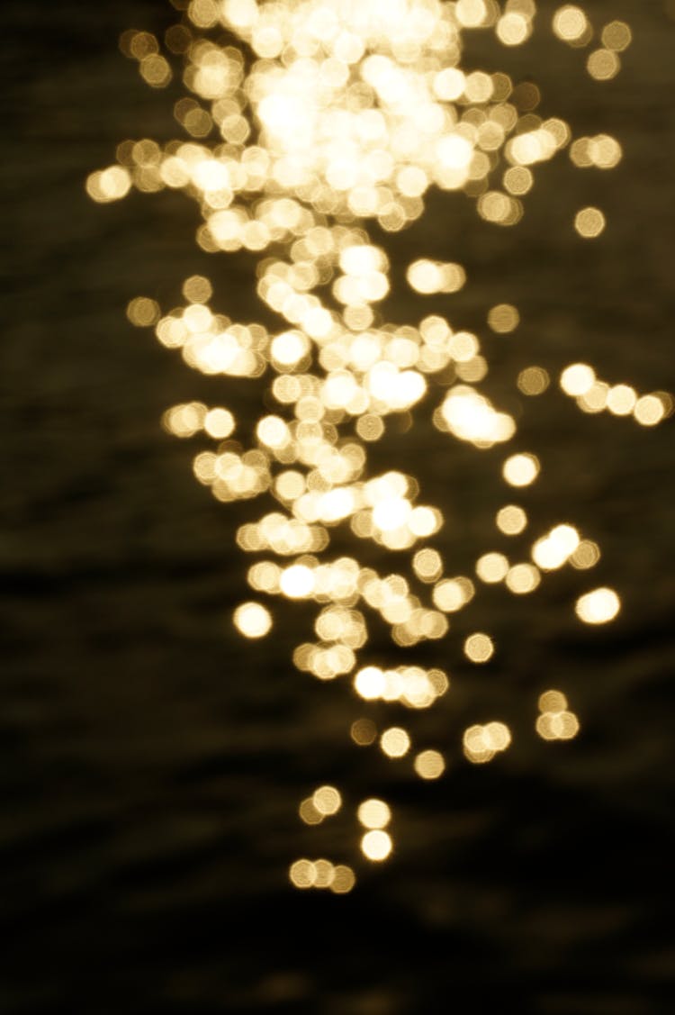 Abstract Photo Of Yellow Lights Glittering On Water Surface