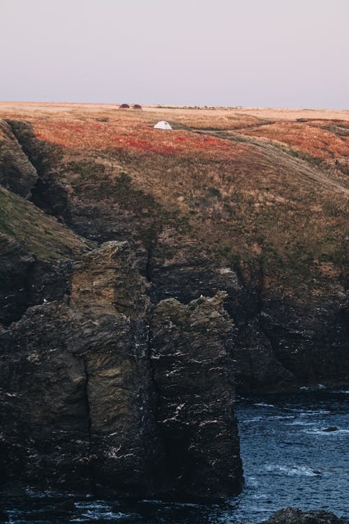 Brown and Green Mountain Beside Blue Sea