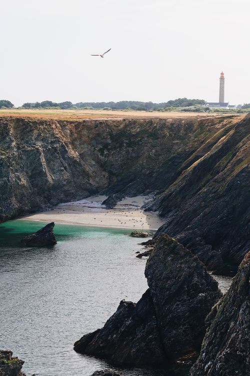 Free A stunning view of rocky cliffs and a lighthouse by the sea in Brittany, France. Stock Photo