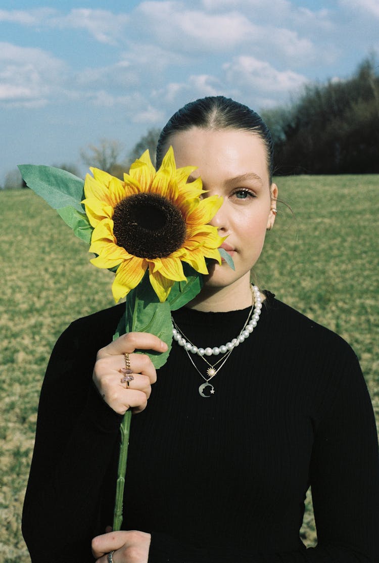 Teenage Girl Holding Sunflower Covering Her Eye