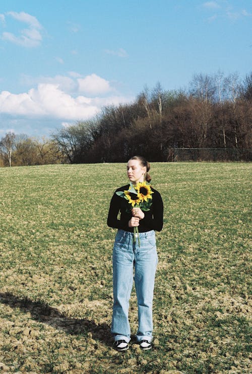 Foto stok gratis bunga matahari, celana denim, kaum wanita