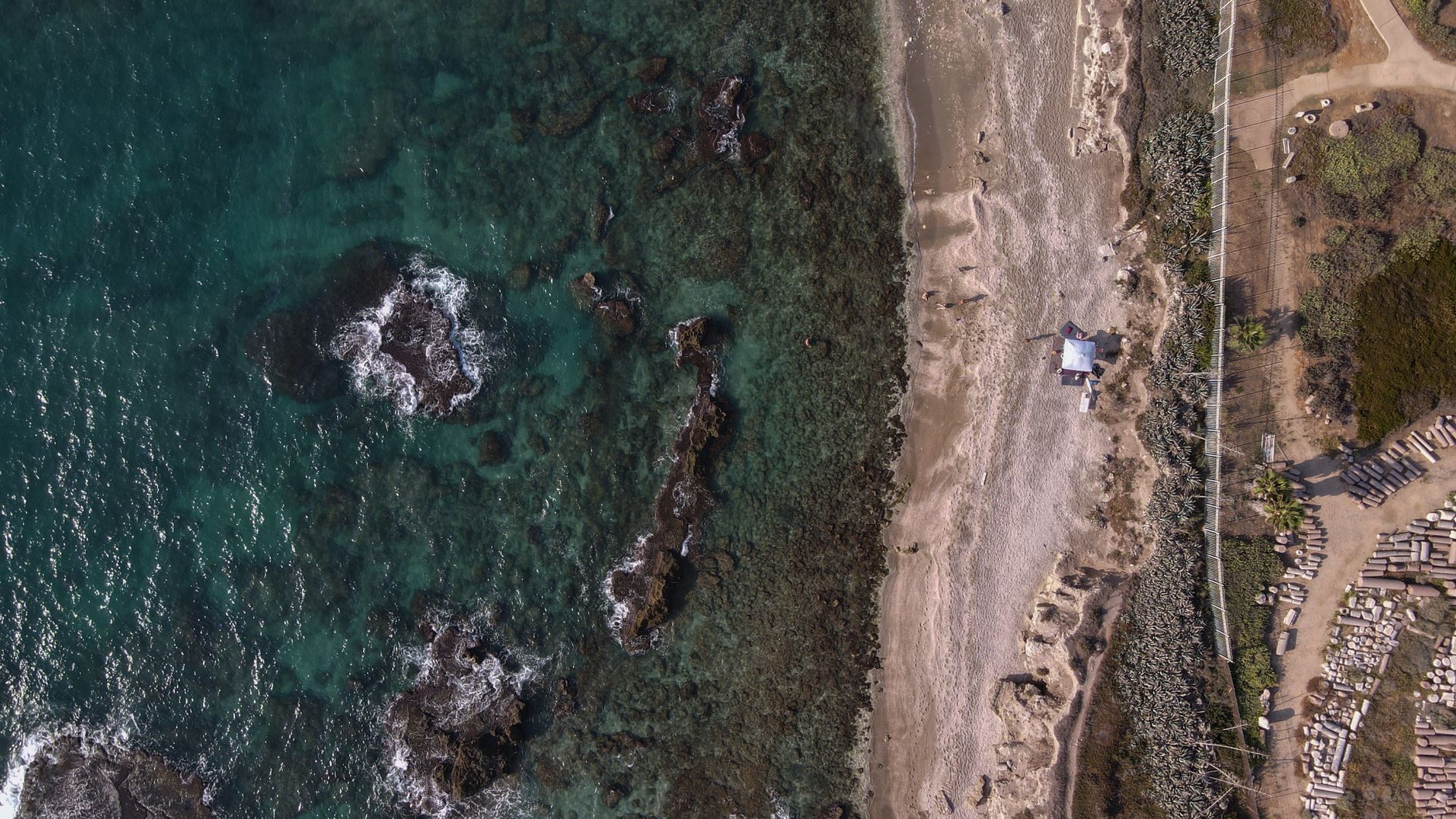 Beautiful aerial view of Caesarea beach coastline, showcasing the vibrant waters and unique landscape.