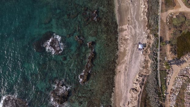 Beautiful aerial view of Caesarea beach coastline, showcasing the vibrant waters and unique landscape.