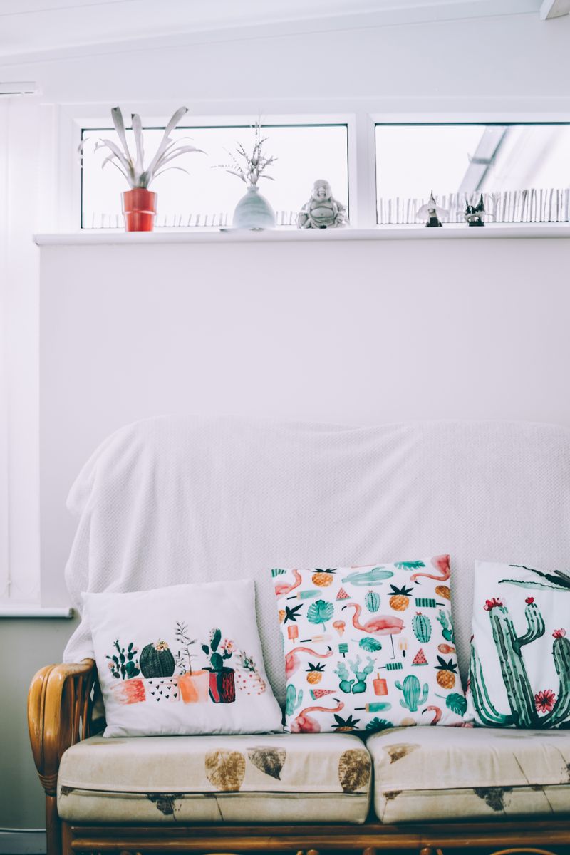 A white sofa with patterned cushions in a bright room