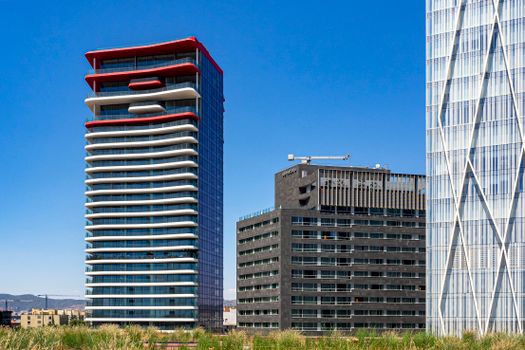 Contemporary skyscrapers under clear blue skies in Barcelona, showcasing urban architecture.
