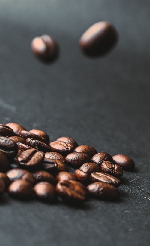 Free Dynamic shot of roasted coffee beans falling, capturing the essence of freshness. Stock Photo