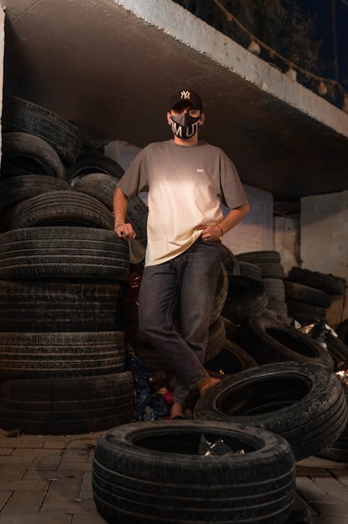 Man in Gray Shirt near Tires