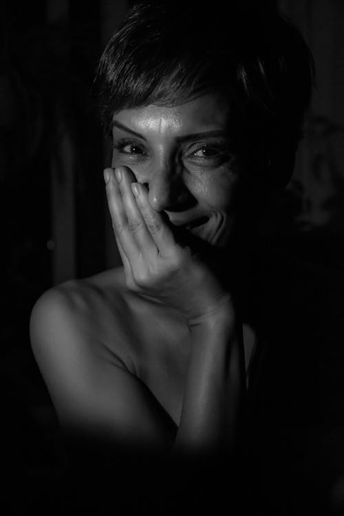 Grayscale Photo of Woman Covering Her Face With Her Hand