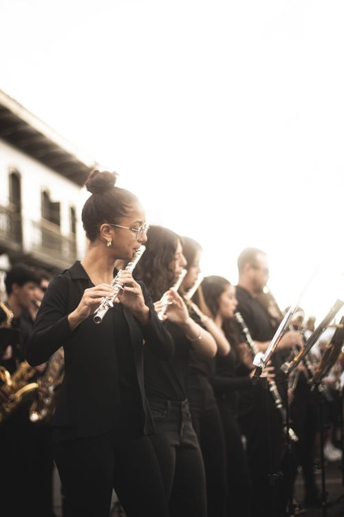 Free Musicians performing in an outdoor setting, featuring a group of flute players in an orchestra. Stock Photo