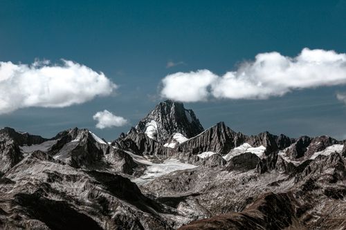 Free Breathtaking view of a snow-capped mountain range with clear skies and clouds. Stock Photo
