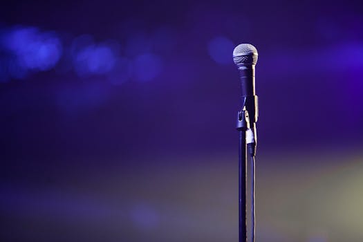 A dynamic photo of a microphone on a stand against a vibrant purple backdrop, suitable for music themes.
