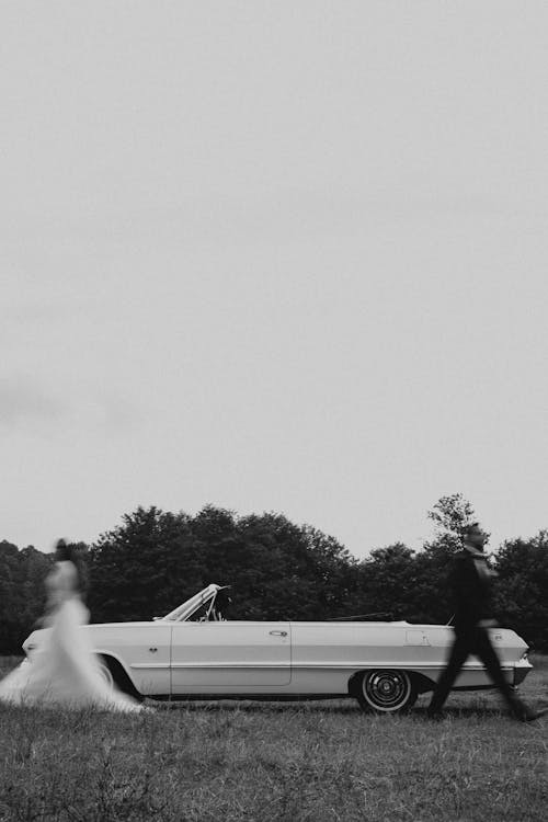 Bride and Groom Walking Opposite Beside White Car