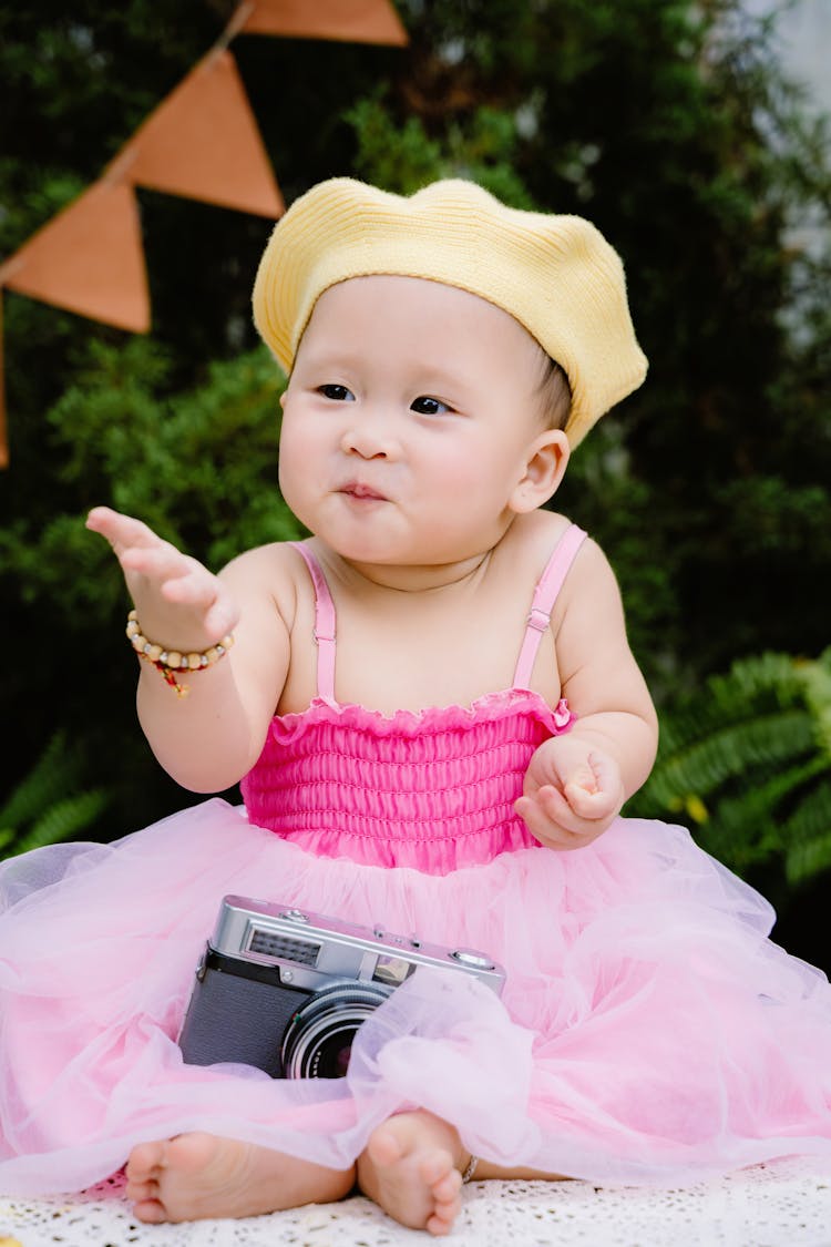 Cute Baby Girl Wearing Yellow Beret And A Pink Dress