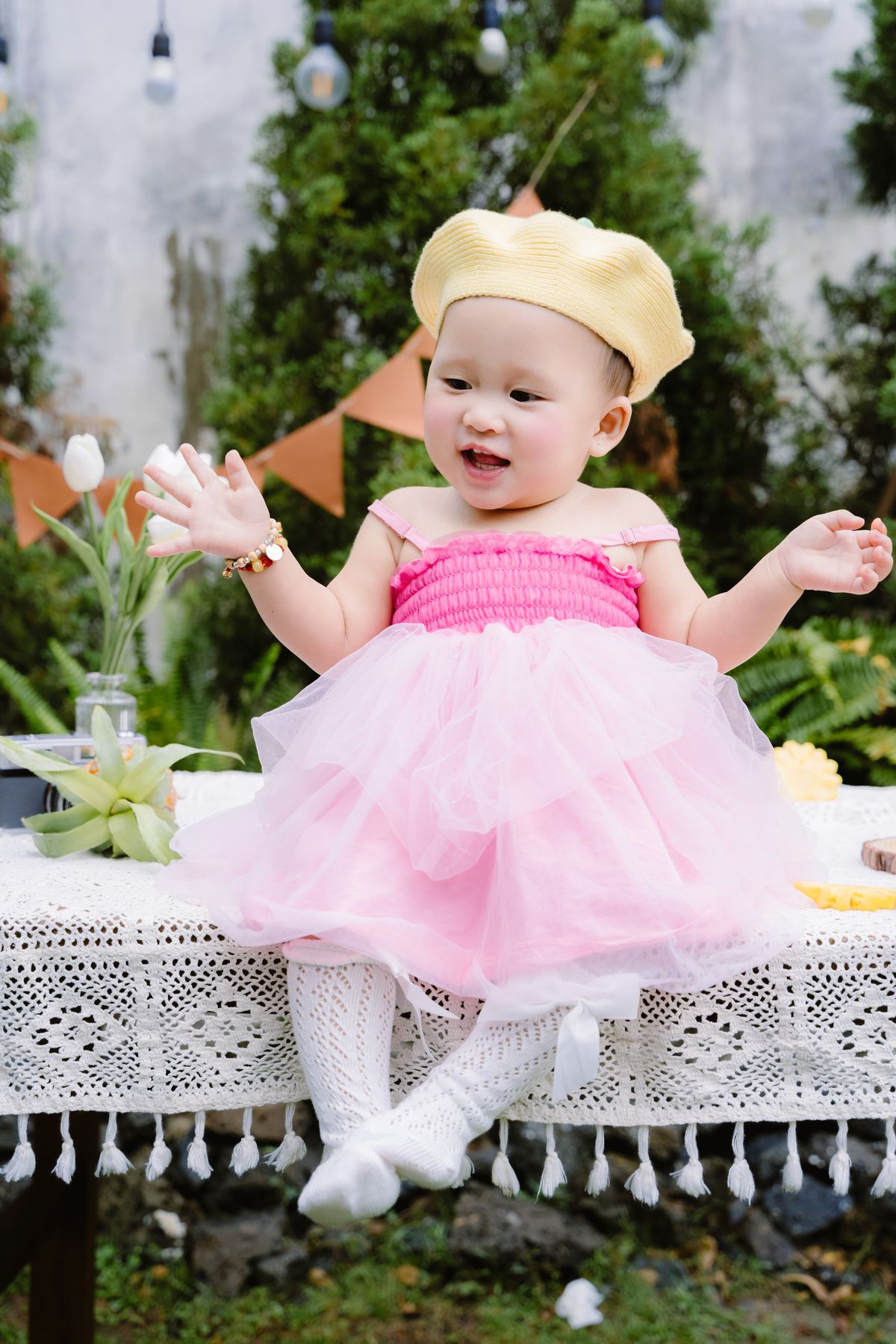 Baby in a pink tutu dress with a yellow beret