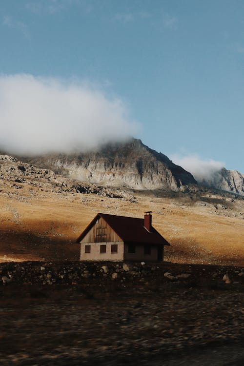 Free White and Brown House Near Mountain Under White Clouds Stock Photo