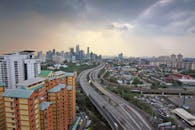 鸟瞰吉隆坡日落时的天际线，可见现代建筑与高速公路