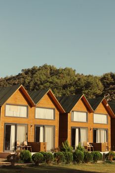 Charming wooden bungalows set against a lush forested backdrop, perfect for nature retreats.