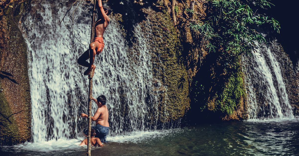 Local children swimming in the pool at the base of Wli Waterfalls