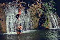 男孩们在泰国瀑布附近攀爬，享受夏日时光