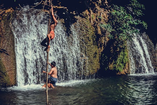 男孩们在泰国瀑布附近攀爬，享受夏日时光