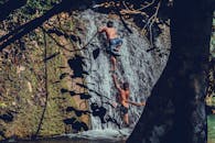 在泰国坦本班泰的小瀑布，两个孩子爬上瀑布，体验大自然的冒险