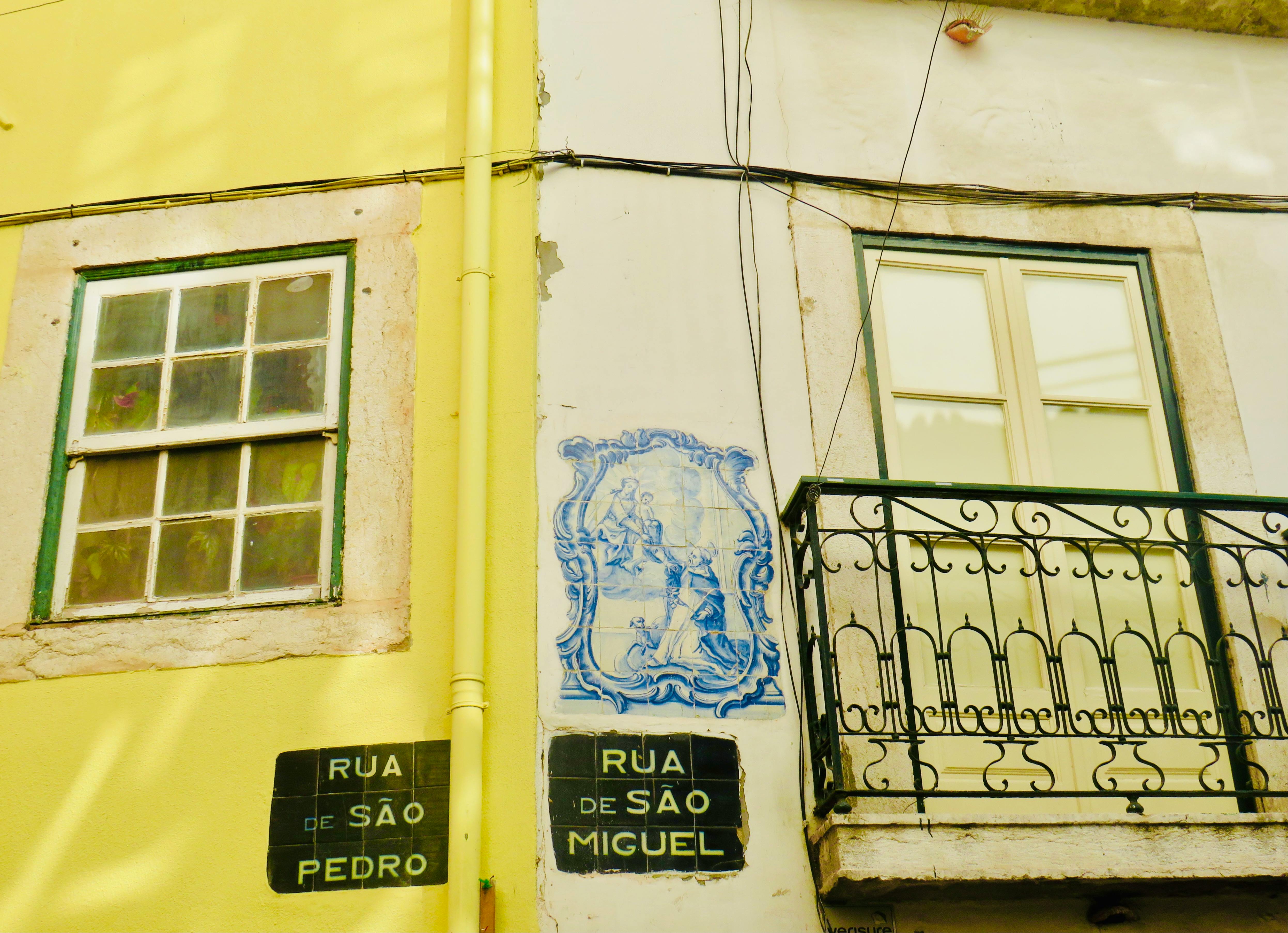 Charming Lisbon street featuring azulejos, balconies, and vibrant architecture.