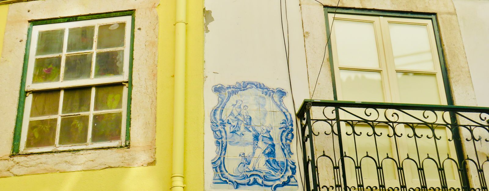 Charming Lisbon street featuring azulejos, balconies, and vibrant architecture.