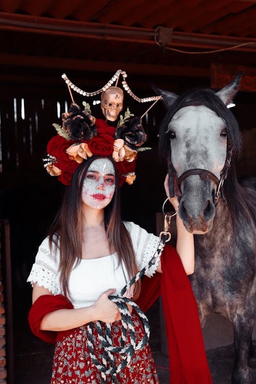 Woman with Face Paint Standing Beside a Horse