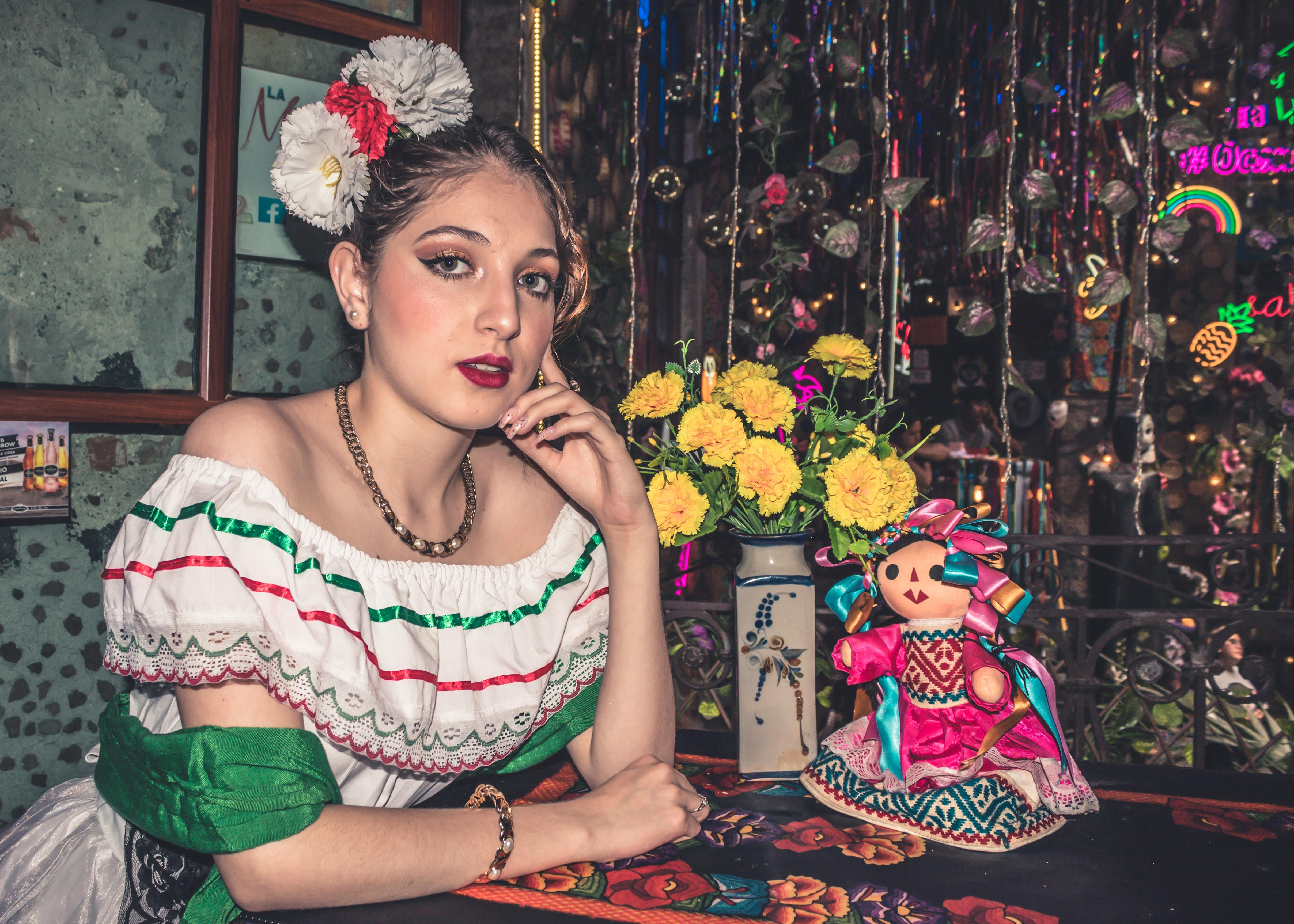 woman in traditional dress sitting with doll