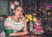 Woman in Traditional Dress Sitting with Doll