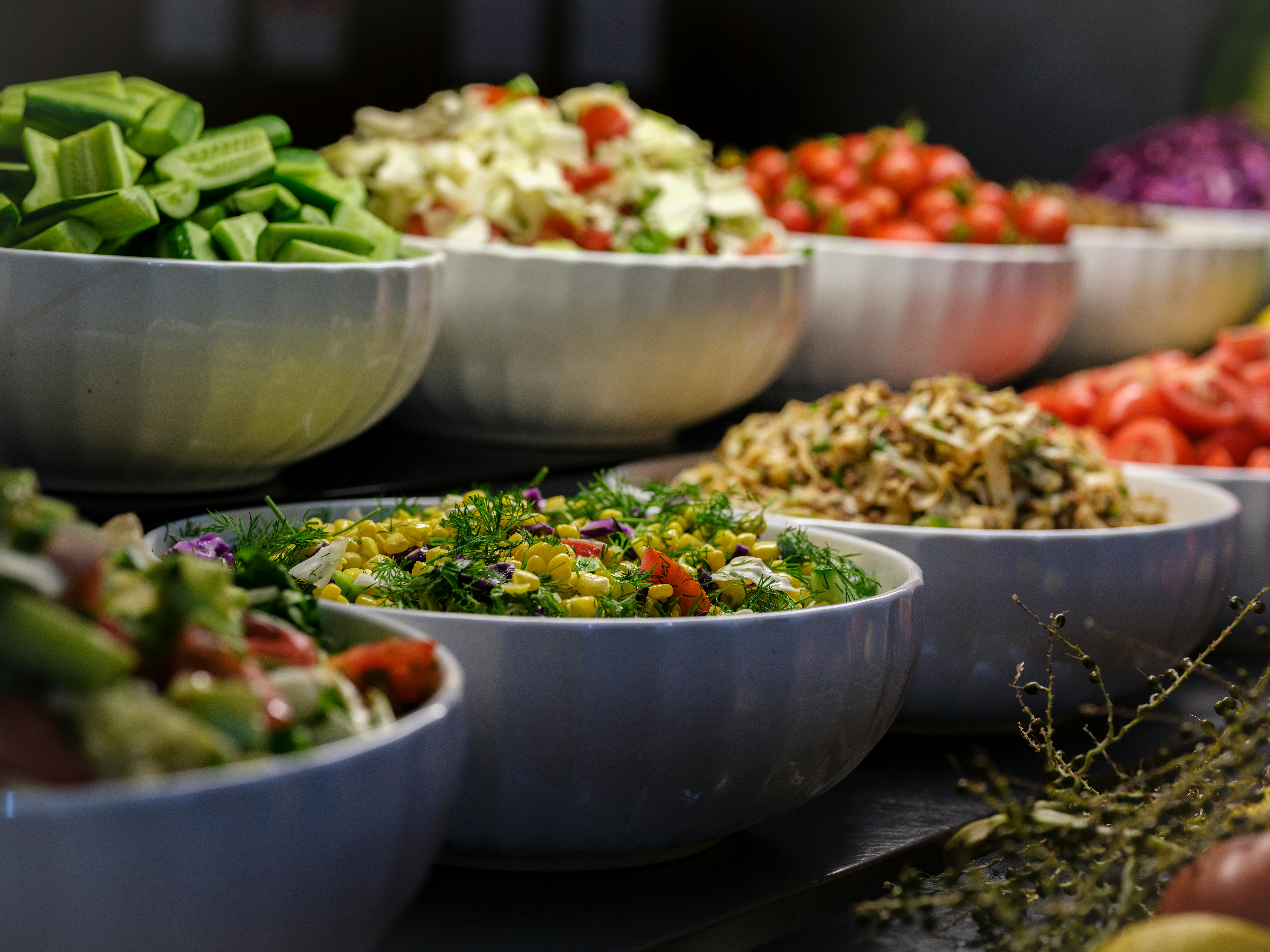 A colorful assortment of fresh salads and vegetables in ceramic bowls. Perfect for healthy food photography.