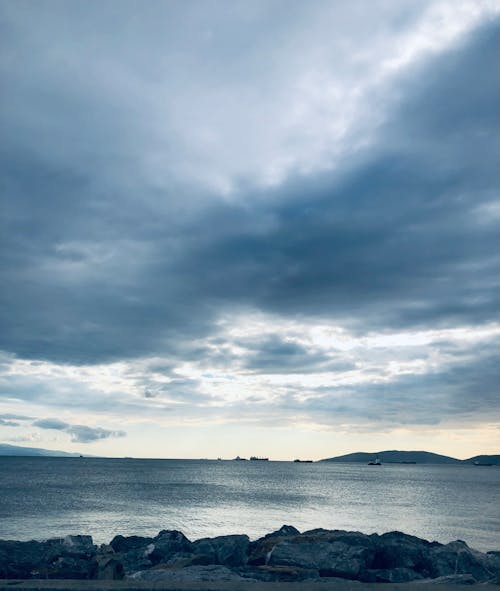 Foto profissional grátis de cênico, céu nublado, costa