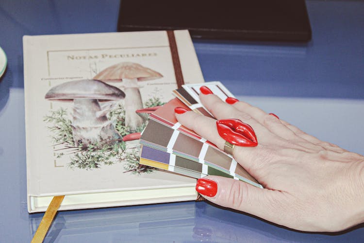 Woman Hand On Book About Mushrooms