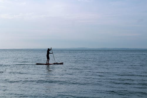 A Person Paddle Boarding at Sea