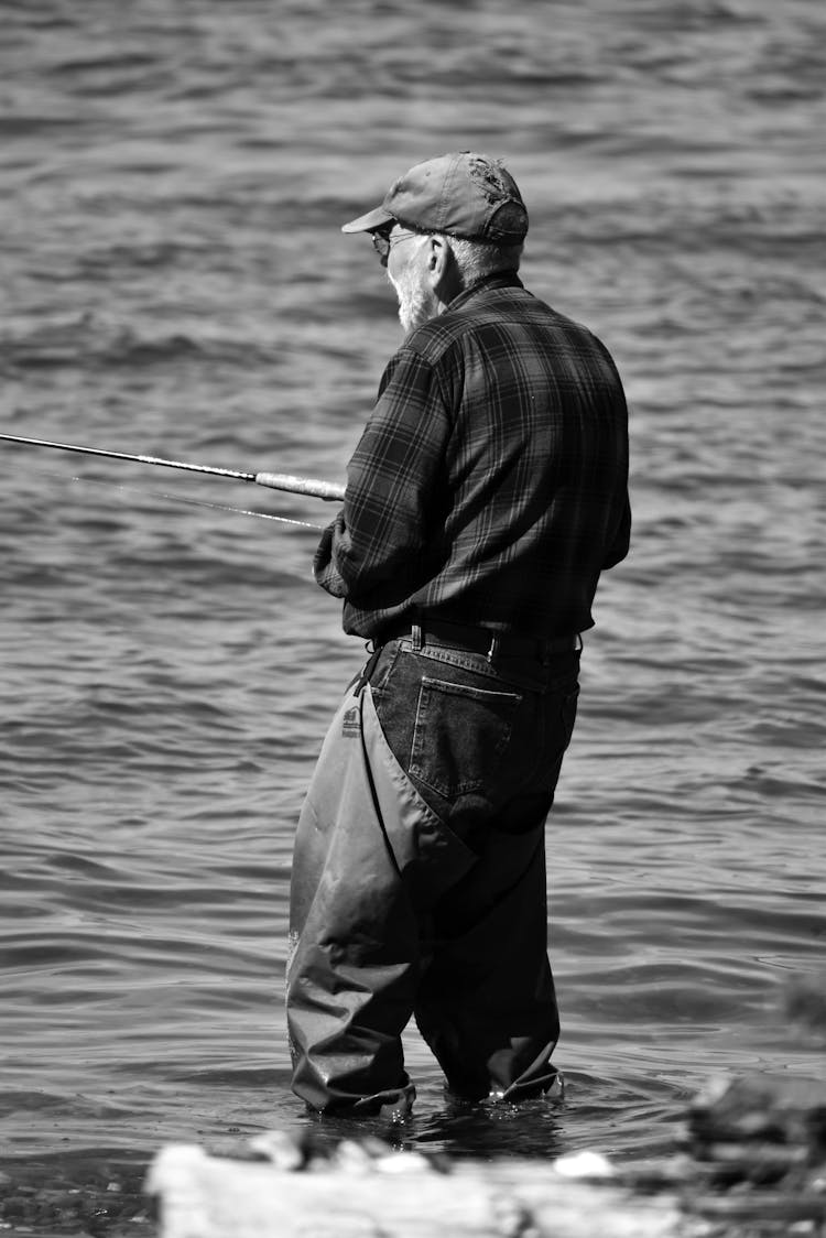 Grayscale Photo Of An Elderly Man Fishing