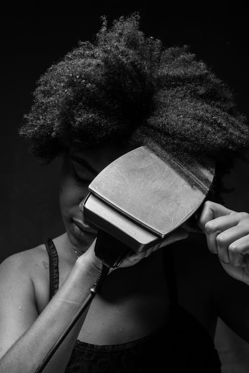 Woman Ironing Her Hair with a Clothes Iron