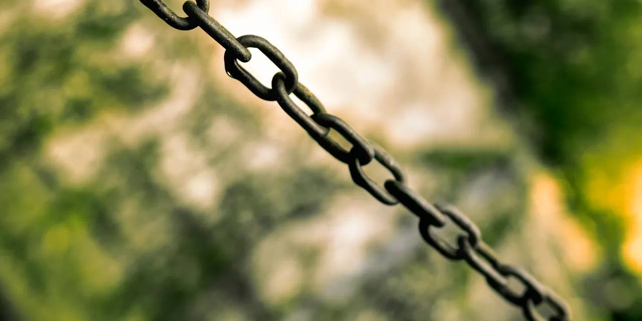 A macro shot of connected metal chain links, illustrating link acquisition and the backlinks that connect one website to another