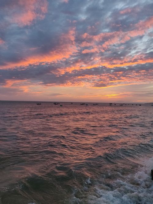 Free Stunning sunset over the ocean at Phan Thiết, capturing dramatic skies and calm waves. Stock Photo