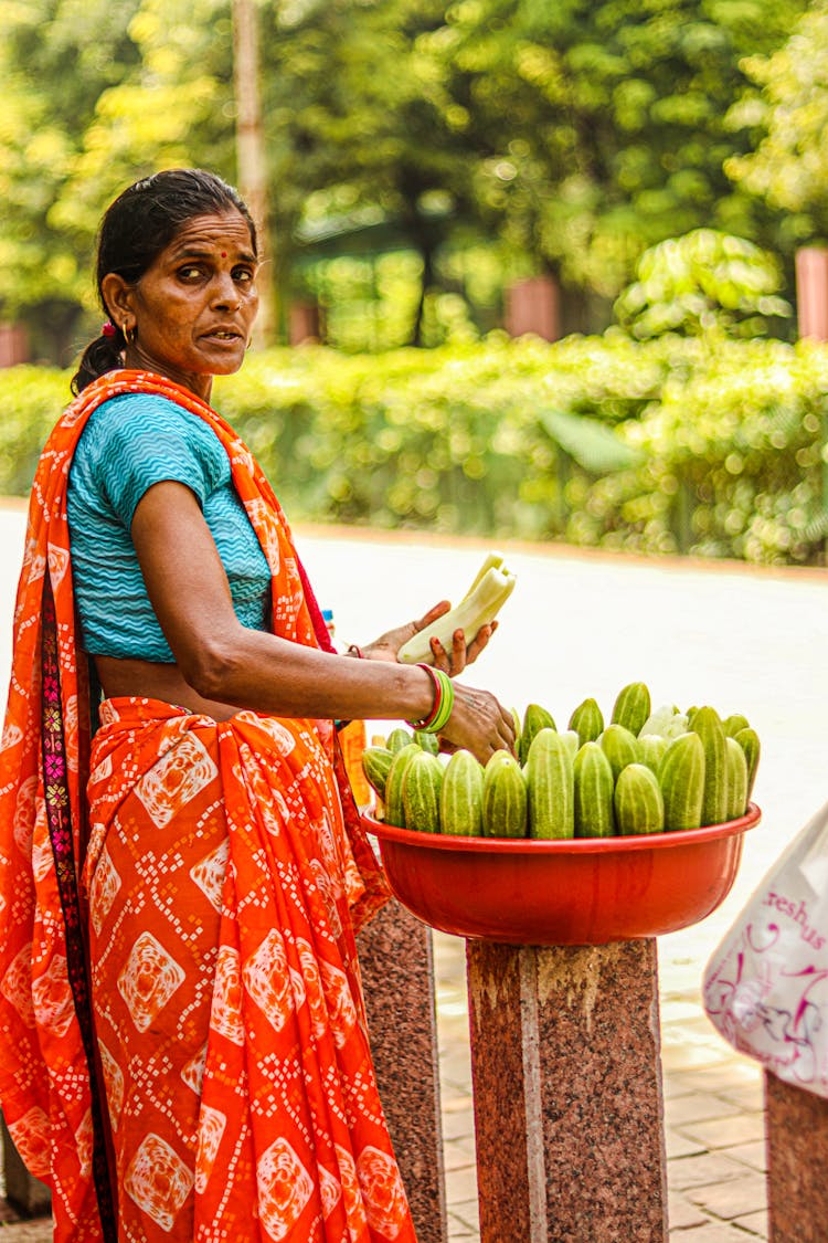 Woman In Traditional Costume With Vegetables On Street