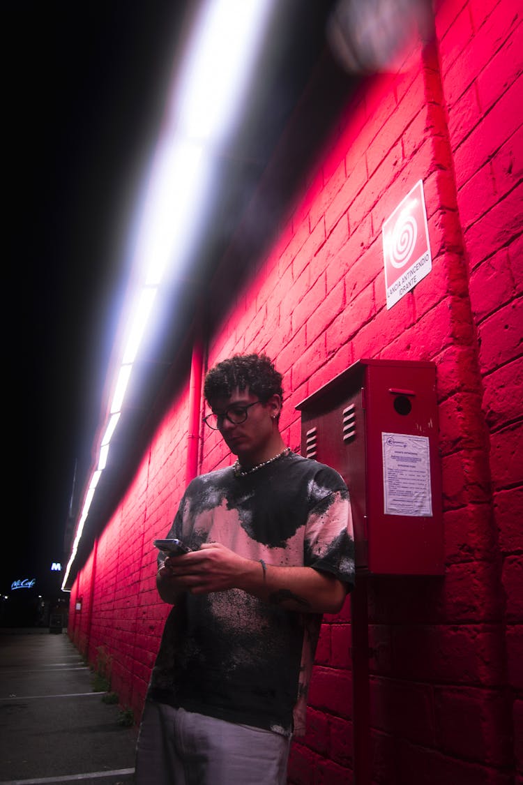 Man Using Smartphone On Sidewalk At Night