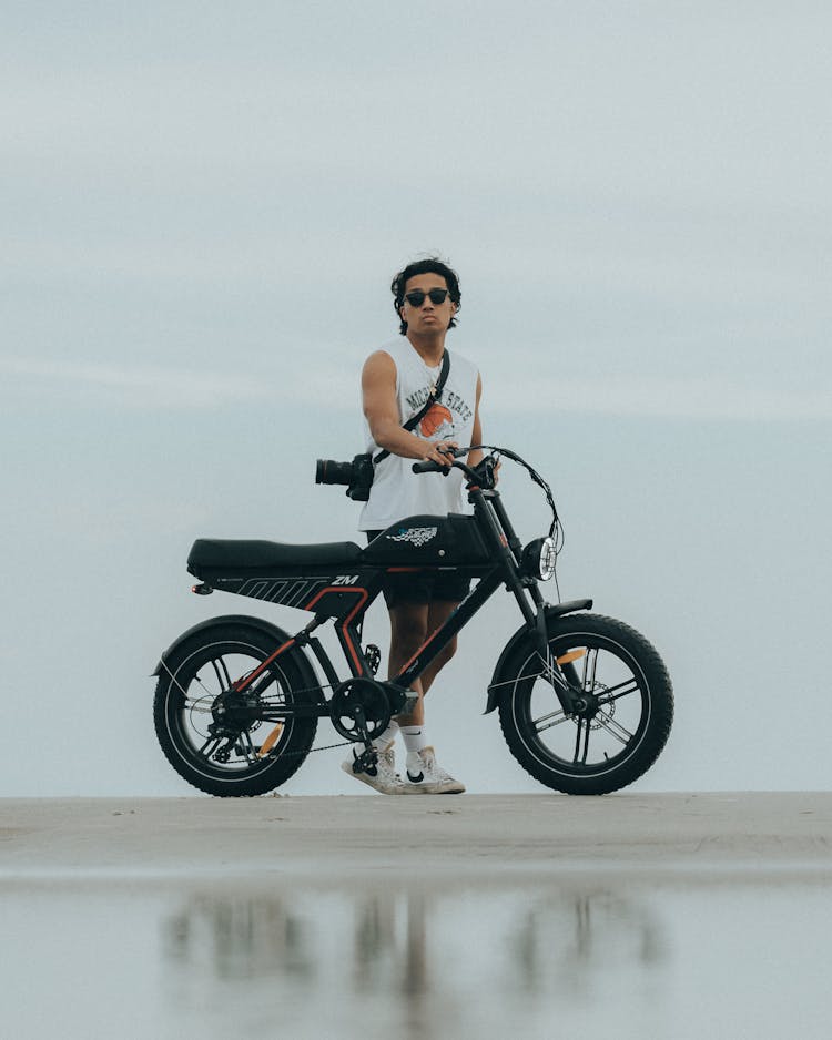 Young Man Pushing A Motorbike 