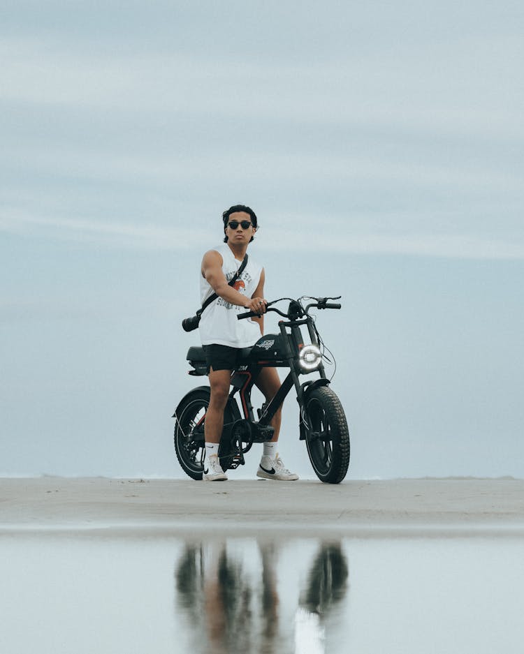 Young Man Pushing A Motorbike 