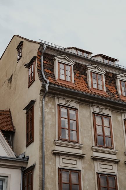 Low-angle view of a historic building with ornate windows and brick facade.