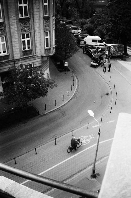 High-angle monochrome view of cyclist on a street in Kraków, Poland.