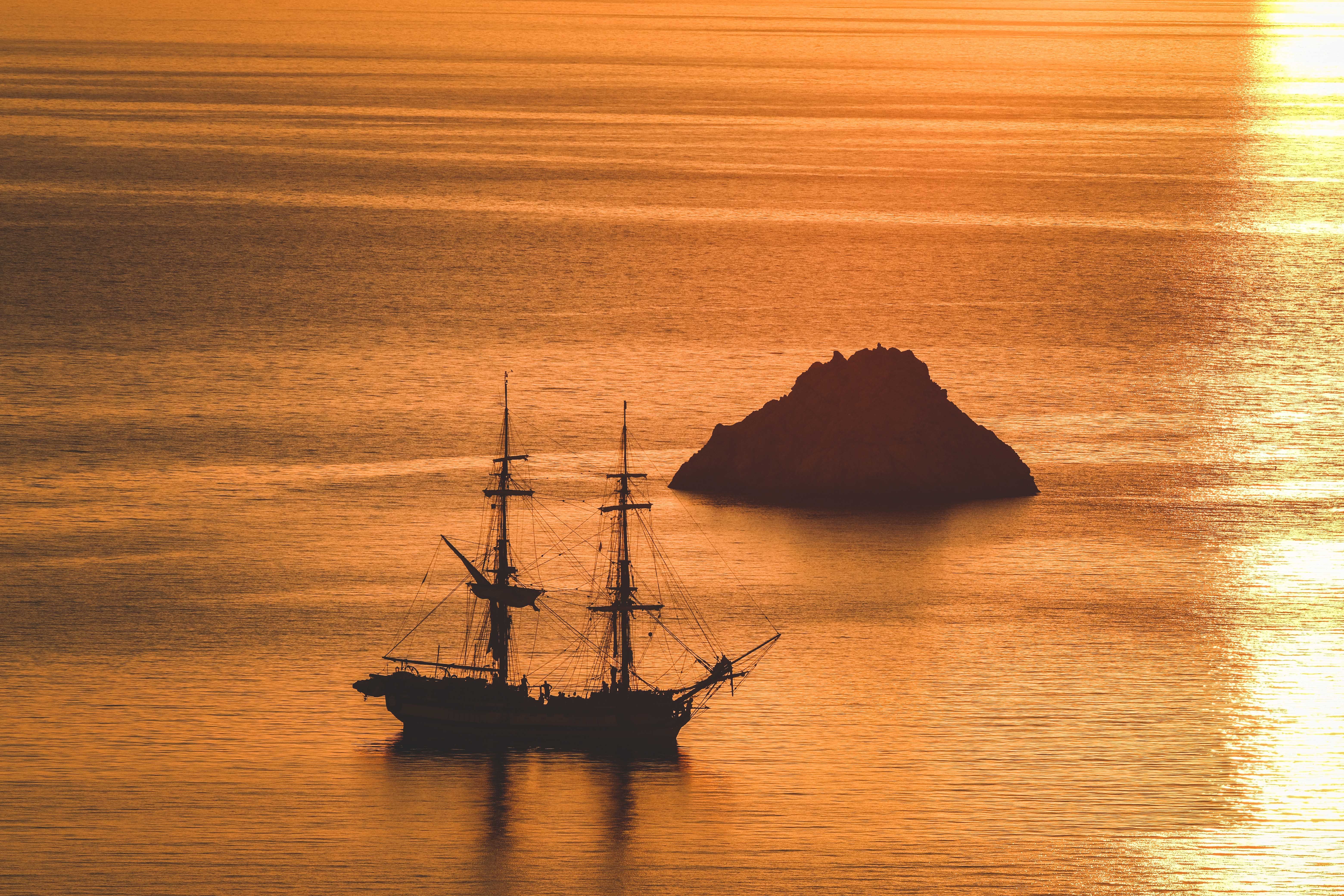 Silhouette of a Ship at Sea During Golden Hour · Free Stock Photo
