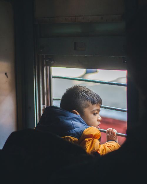 Free Young boy gazes out of a train window in Delhi, capturing a moment of travel and curiosity. Stock Photo