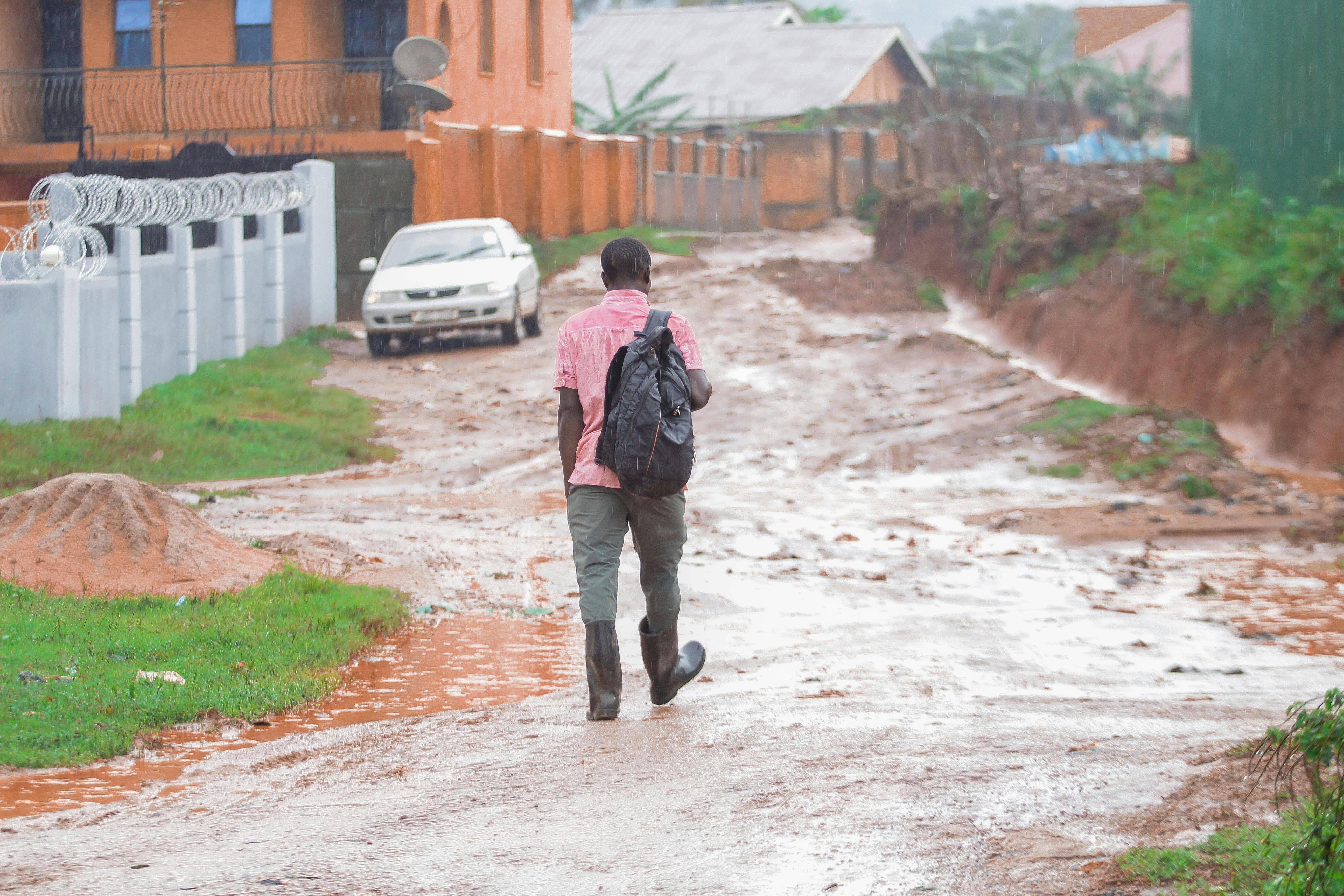 Muddy unpaved road leading to Christ Embassy Ho Loveworld Arena with people walking