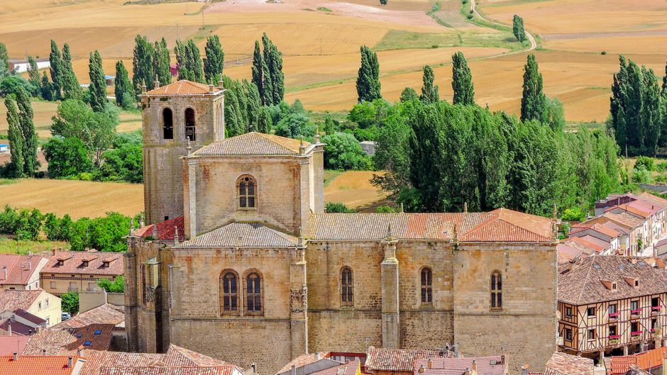 Iglesia gótica en Peñaranda de Duero, rodeada de campos rurales, destino de viaje perfecto.