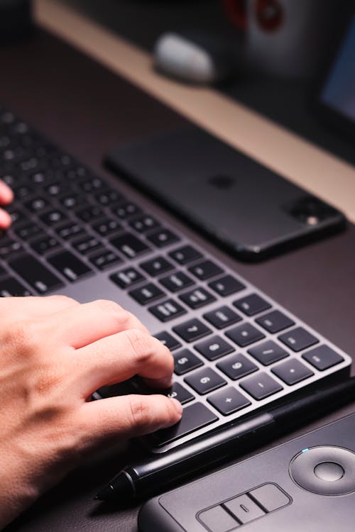 A Man Typing on Black Keyboard