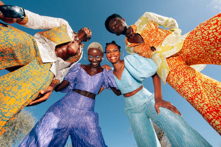 Low Angle View Of Men And Women In Colorful Suits 